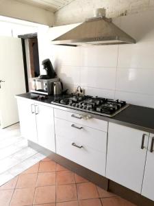 a kitchen with white cabinets and a stove top oven at Apartment in Nijmegen voor 3 personen in Kranenburg