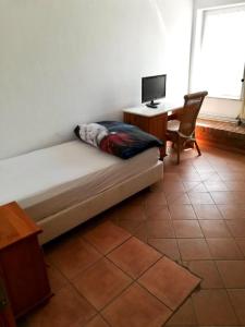 a bedroom with a bed and a desk and a chair at Apartment in Nijmegen voor 3 personen in Kranenburg