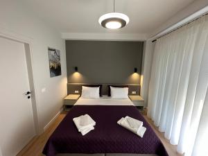 a bedroom with a bed with two white towels on it at Soin Rooms in Tirana