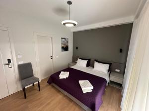 1 dormitorio con 1 cama grande y 1 silla en Soin Rooms en Tirana