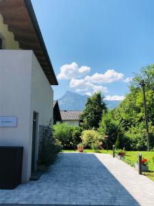 a walkway outside of a house with mountains in the background at One Apartment in Salzburg