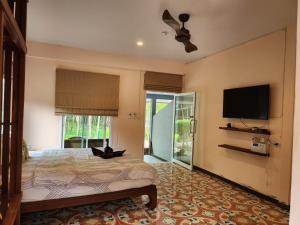 1 dormitorio con 1 cama y TV de pantalla plana en Baan NomTham, en Ko Lanta