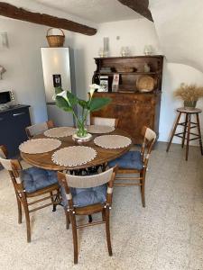 a dining room with a table and chairs with a plant at Maison de village 5 vacanciers chez Néné et Bibi in Roquemaure