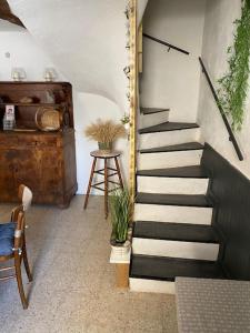 escalera en una habitación con mesa y taburete en Maison de village 5 vacanciers chez Néné et Bibi, en Roquemaure