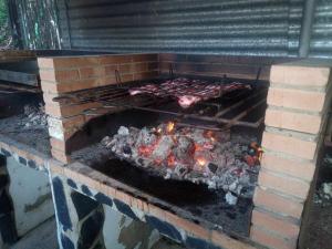 um forno de tijolos com carne e outros alimentos para cozinhar em Alojamientos Rurales Berrocal em Berrocal