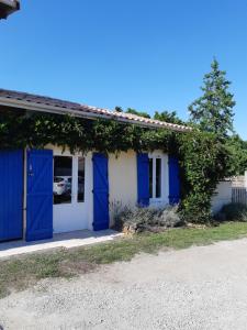 un edificio azul y blanco con puertas azules en Gîte le Chai en Le Teich