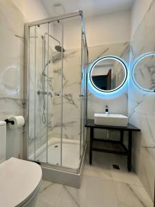 een badkamer met een douche, een wastafel en een spiegel bij Escape Pensiune in Bechet