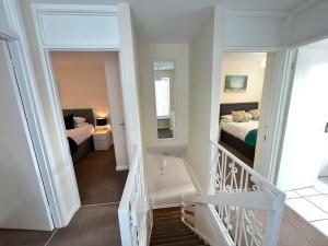 a staircase leading to a bedroom with a bed at Penny Cottage By The Beach in Portsmouth