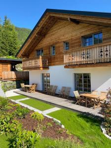 a house with a deck and a table and chairs at Chalet Tannalm in Bad Kleinkirchheim