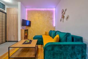 a living room with a green couch and a table at Zlatibor apartman Trifunovic Luxury&Spa in Zlatibor