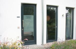 uma porta preta numa casa branca com duas janelas em Ferienwohnung Die Traumhafte em Kleve