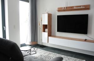 sala de estar con TV de pantalla plana en la pared en Ferienwohnung Die Traumhafte en Kleve