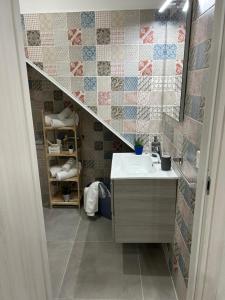 ein Badezimmer mit einem Waschbecken, einem Spiegel und einer Treppe in der Unterkunft Casa Elivì Ballaró 2 passi dal centro storico, parcheggio e stazione ferroviaria in Palermo + 27 Fotos