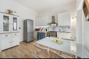 a kitchen with white cabinets and a table with chairs at Casa Cattedrale in Iglesias