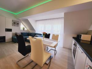 a kitchen and living room with a table and chairs at Heviz Victoria apartman in Hévíz