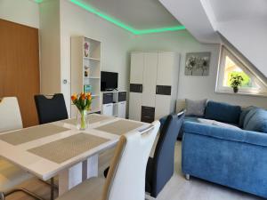 a living room with a table and a blue couch at Heviz Victoria apartman in Hévíz