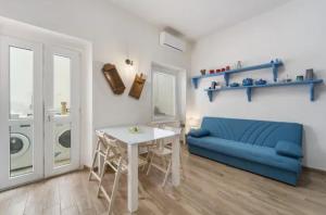 a living room with a blue couch and a table at Casa Cattedrale in Iglesias