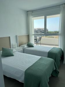 two beds in a room with a large window at Apartamento luxury frente al mar in Valencia
