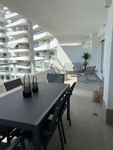 a room with a table and chairs on a balcony at Apartamento luxury frente al mar in Valencia