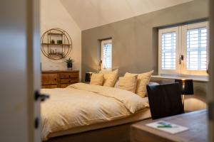 a bedroom with a large bed and a table at B&B Rosselaer in Balen