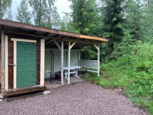a shed with a picnic table and a bench at Koivuisenranta in Kalmari