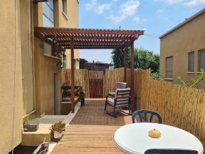 une terrasse en bois avec une pergola et une table dans l'établissement בין הר למעיין, à Kefar Tavor