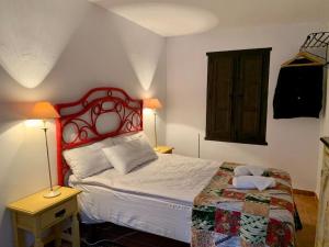Townhouse in Canillas de Aceituno في Canillas de Aceituno: غرفة نوم مع سرير مع اللوح الأمامي الأحمر
