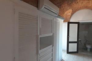 a bathroom with a white door and a toilet at Affitti Brevi Toscana - Forte Militare Talamonaccio in Fonteblanda