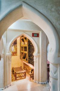 an archway with a table and a bench in a room at Riad Hicham in Chefchaouen