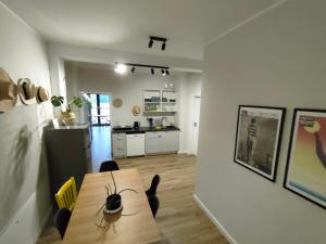 a living room with a table and a kitchen at Willa Powolutku in Ostrzyce