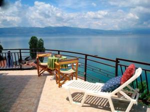 een patio met 2 stoelen en een tafel met uitzicht op het water bij Villa Elena in Trpejca