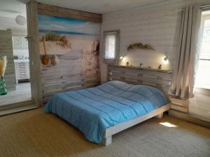 a bedroom with a blue bed in a room at COCOON in Lagorce