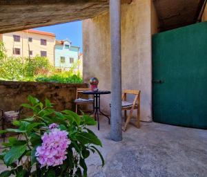 een patio met een tafel, een stoel en bloemen bij 2 Bedroom Apartment Ljubica Sinj in Sinj