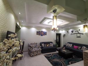 a living room with couches and a chandelier at 2 bedroom, 4 beds, apartment in El sheikh Zayed Cairo Egypt in Sheikh Zayed