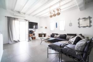 a living room with a couch and a table at Villa with Private Pool in Panormos in Mykonos