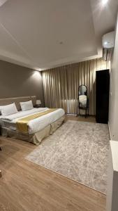 a hotel room with two beds and a chair at منازل الشمال للشقق المخدومة Manazel Al Shamal Serviced Apartments in Hail