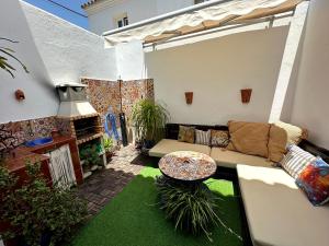 a patio with a couch and a table in a yard at La Barrosa duplex in Chiclana de la Frontera