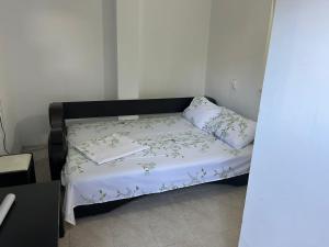 Una cama con una manta blanca y almohadas. en Vila Vio 2 camere independente, en Eforie Nord