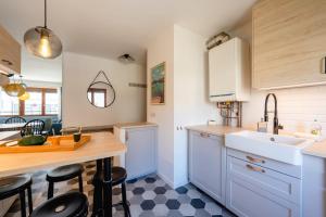 アヌシーにあるLes Hirondelles - Appartement 3 chambres à Annecyのキッチン(シンク、カウンター、スツール付)