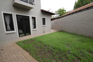 a backyard of a house with a green lawn at Apartment @ Silver Lakes in Pretoria