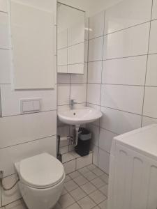 Baño blanco con aseo y lavamanos en Studio Apartment mit Balkon 13-2L1, en Essen