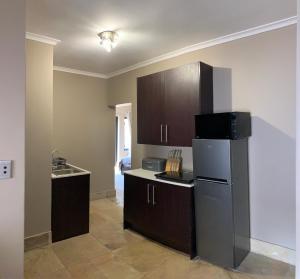 a kitchen with a refrigerator and wooden cabinets at Apartment @ Silver Lakes in Pretoria