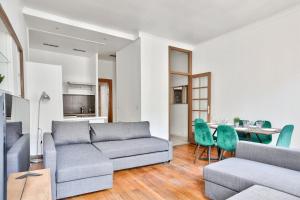 a living room with a couch and a table and chairs at Appartement Quartier Champs-Élysées in Paris