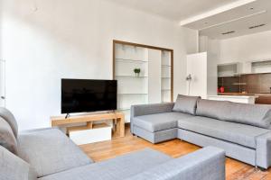 a living room with two couches and a flat screen tv at Appartement Quartier Champs-Élysées in Paris