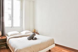 two beds in a room with white walls at Appartement Quartier Champs-Élysées in Paris