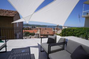 a balcony with a couch and chairs on a roof at ELEVEN in Šibenik