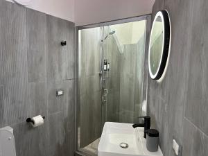 a bathroom with a sink and a shower with a mirror at Beauty Apartment in Catania