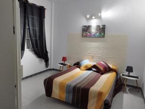 - une chambre avec un lit et une couverture rayée dans l'établissement Apartamentos Blanco Y Negro, à A Guarda