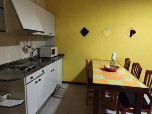 uma cozinha com uma mesa e um micro-ondas em Apartamentos Blanco Y Negro em A Guarda