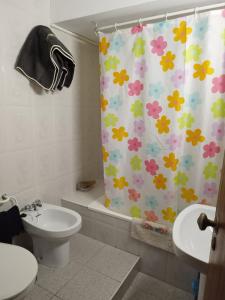 uma casa de banho com uma cortina de chuveiro com flores em Apartamentos Blanco Y Negro em A Guarda